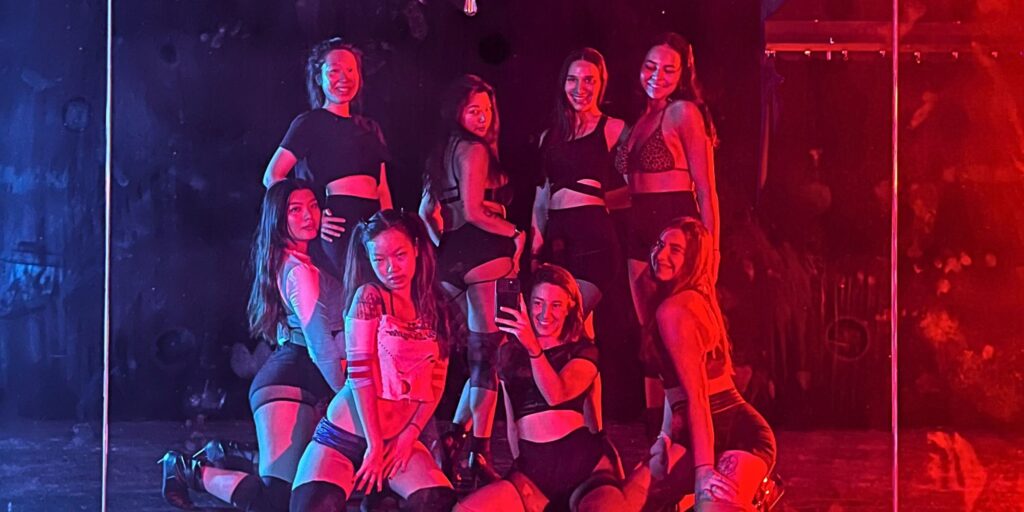group selfie of women in beginner floorwerk dance class with red and blue mood lighting