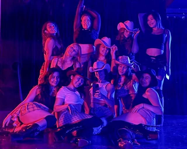 hens party group taking a selfie wearing cowgirl hats in pink mood lighting